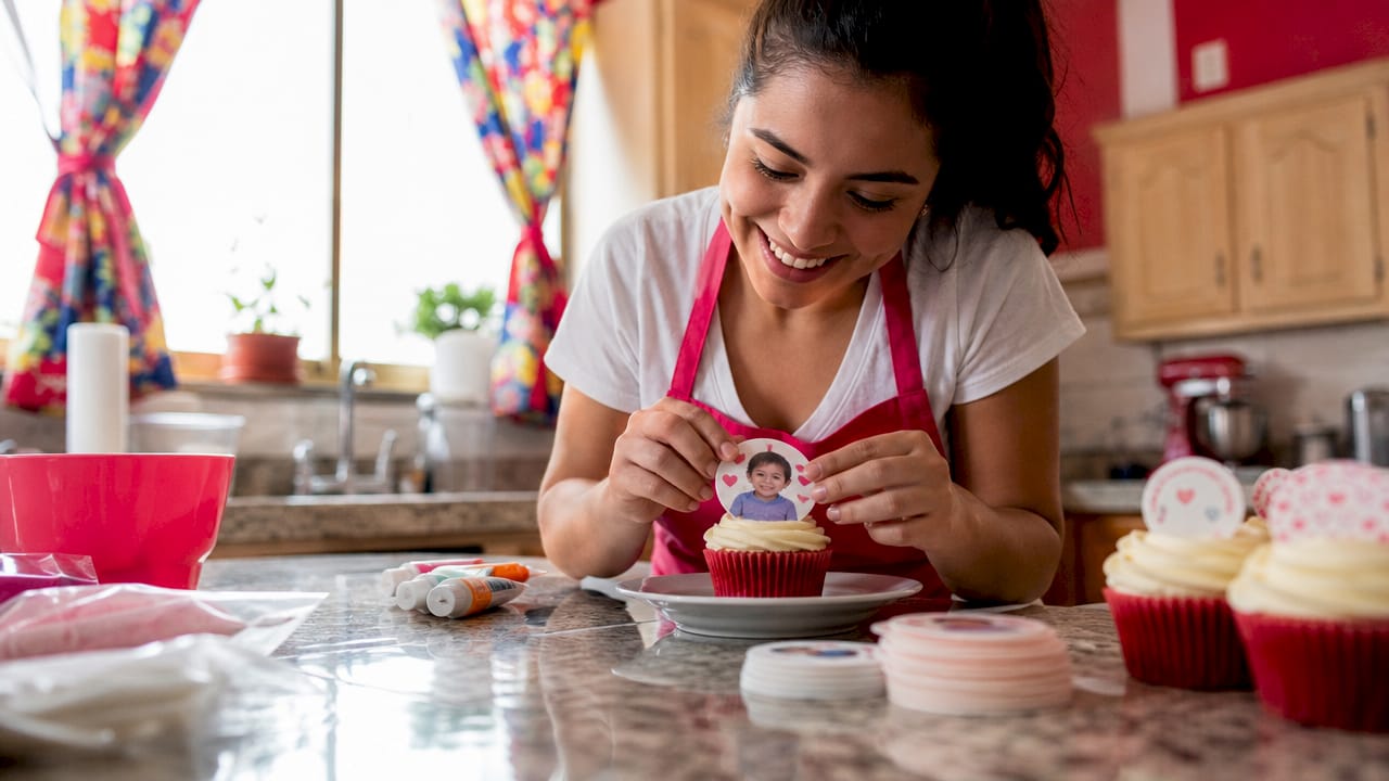 Una mujer da los últimos toques a una oblea personalizada en una pastelería artesanal.