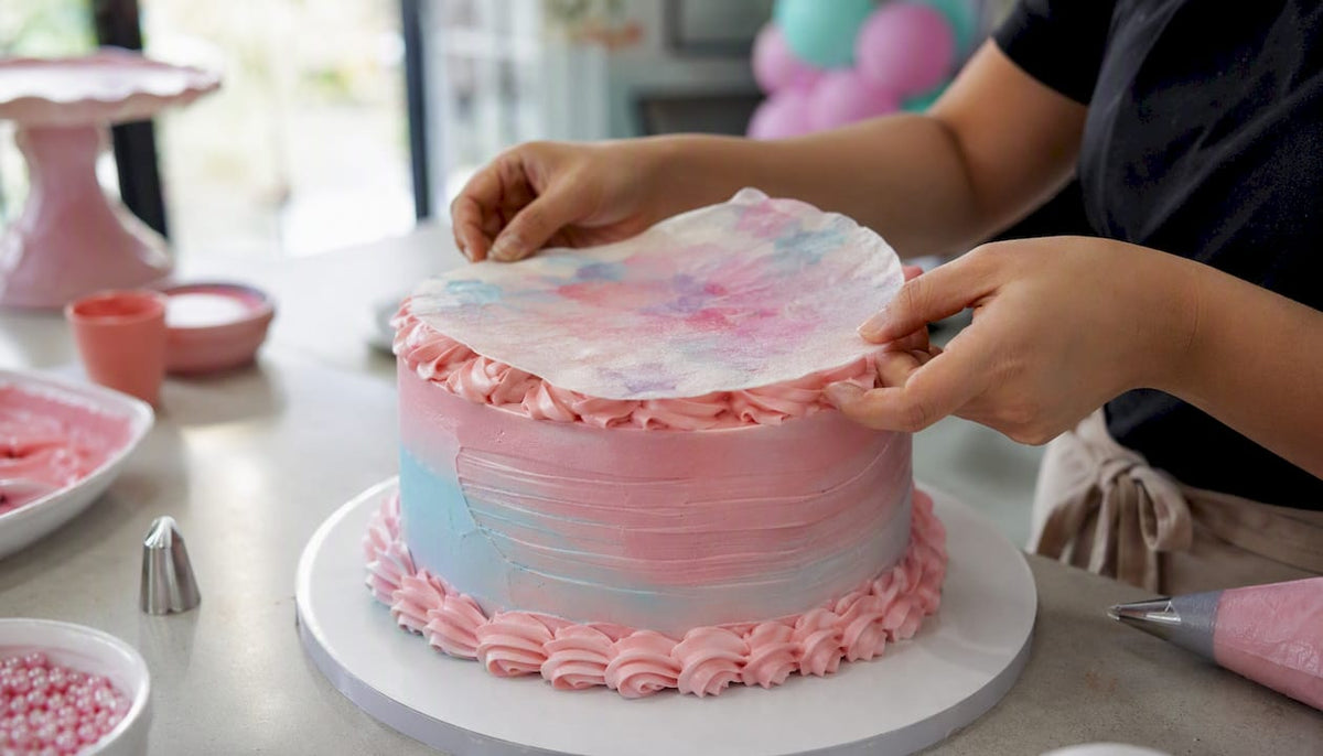 Pasteleiro a decorar o bolo com uma folha comestível