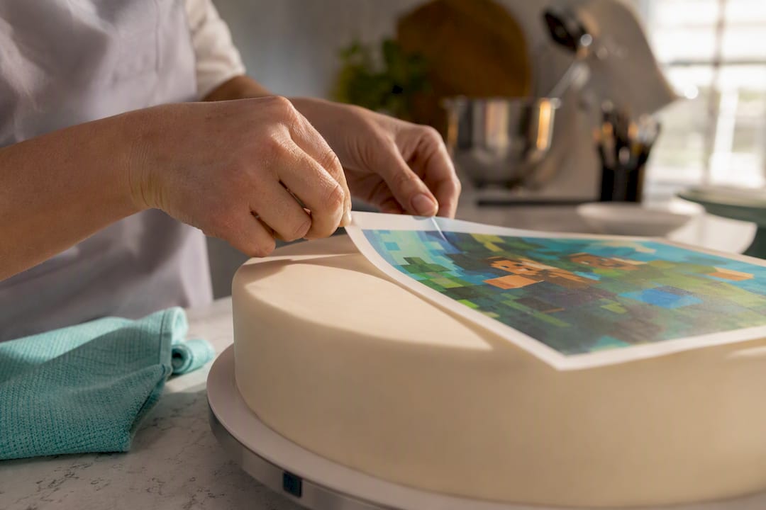 Aplicação cuidadosa de papel comestível numa tarte