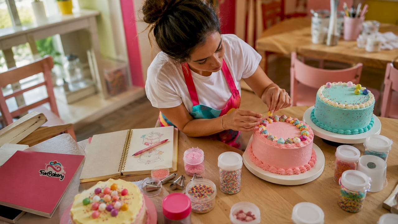 Mujer diseñando y decorando tartas de cumpleaños con un toque moderno
